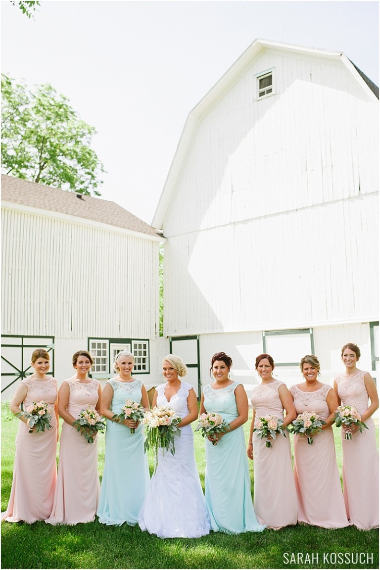 Bride with bridesmaid in front of barn