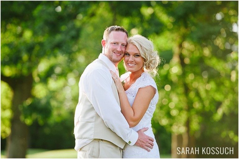 Bride and groom pose on golf course