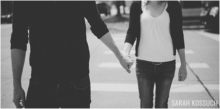 Black and white, couple holds hands while walking